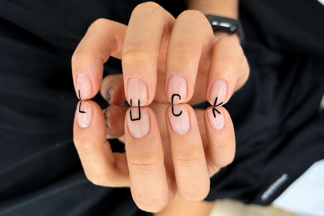 Clean natural-gloss manicure with minimalist hand-painted lettering at Passionate Nails, Great World